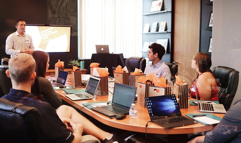 A team in an office discussing the proposal management process during a meeting